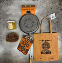 Load image into Gallery viewer, Chuckwagon Waffle Iron Gift Set Bundle from Rome, including cast iron waffle iron, storage cover, seasoning oil, and cleaning brush, displayed on a gray surface - closeup view