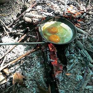 Cooking eggs over a campfire